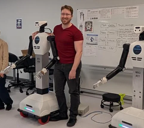 Steven Rice with humanoid robots at the Humanoid Application Lab